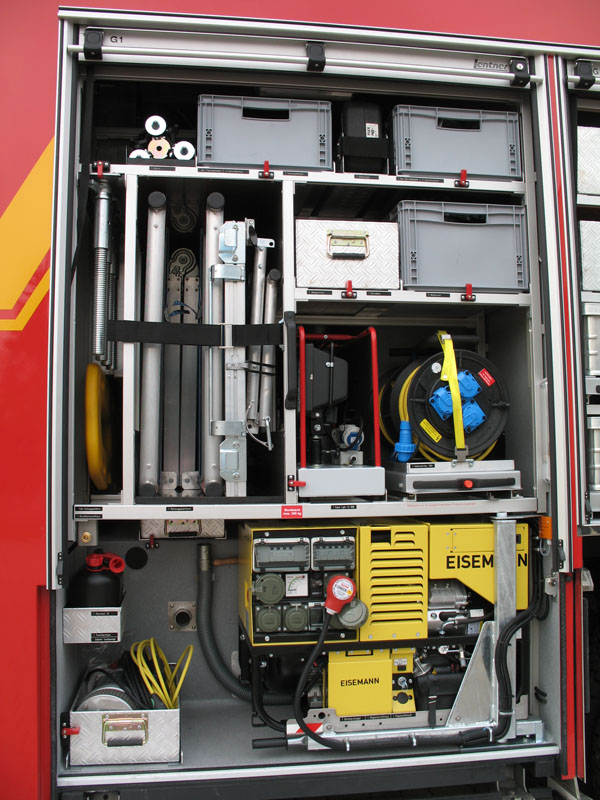 Blick in den Geräteraum G1:

Stromerzeuger Eisemann 13,4 kVA, Kabeltrommeln, Beleuchtungsgerät, Tauchpumpe, Rettungsplattform, Druckluftanschluss, Wathosen, Trennschleifer, Säbelsäge